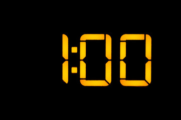 Electronic digital clock with yellow numbers on a black background shows the time one zero zero at...