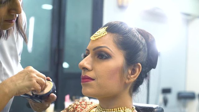 Beauty salon master doing makeup of a young beautiful girl, closeup shot