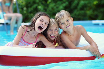 young children have joy in the pool on a hot summer day