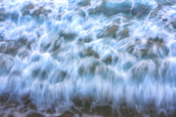 blurry ocean wave on a sandy beach.background