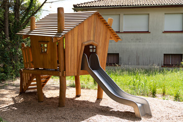 playground in urban park forest with wooden hut and slide - Powered by Adobe