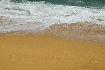 Fototapeta na wymiar Rolling waves over golden sand, Sithonia, Greece