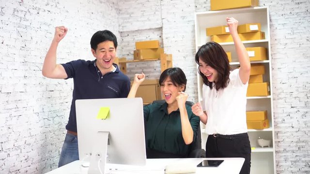 Asian businessman and business women celebrating success and victory in small office