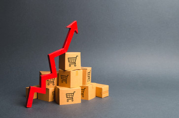 A pile of cardboard boxes with drawing of shopping carts and a red up arrow. The growth rate of...