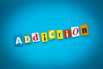 A word writing text - addiction - from colorful letters on a blue background. Headline, card with inscription. Psychologic concept. Caption, heading from colored letters. Message on poster. Single 