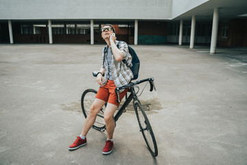 Man posing next to his bicycle.