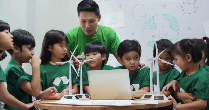 Teacher explaining to student in classroom about ecology project. Technology and Education concept.