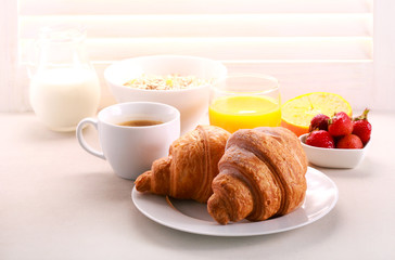 Breakfast with croissant, orange juice, and coffee served