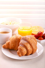 Breakfast with croissant, orange juice, and coffee