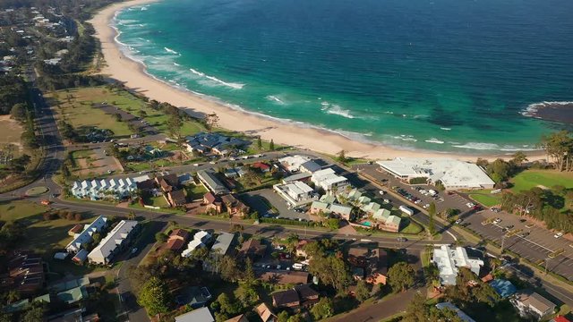 Aerial, tracking, drone shot panning around the Mollymook coast and a beach, on a sunny, summer day, in Shoalhaven region, New South Wales, Australia