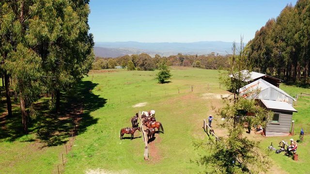 Aerial view of guest ranch with groups of horses and tourists.
