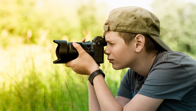 Young photographer shooting nature with SLR camera