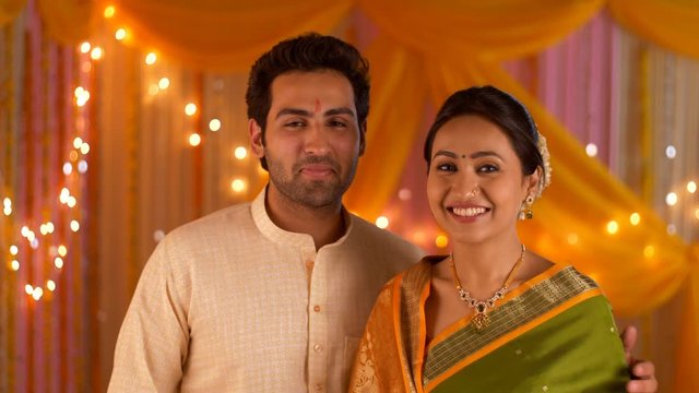 Happy Indian couple facing towards camera - Wearing ethnic traditional dress for a festival. 4K stock footage of Indian couple ready in traditional attire for Hindu customs of festivities