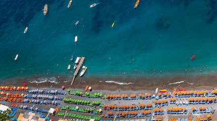 Aerial View of Positano Beach. Beautiful cliff view of Positano beach at daytime, with its beach umbrellas. Amalfi coast situated in province of Salerno, in the region of Campania, Italy.