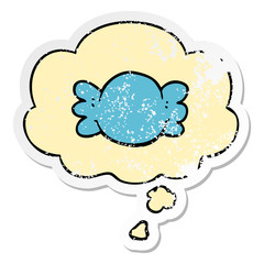 cartoon wrapped candy and thought bubble as a distressed worn sticker