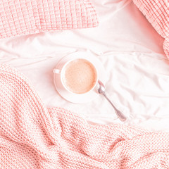 Fototapeta na wymiar Bed with pink knitted plaid and coffee