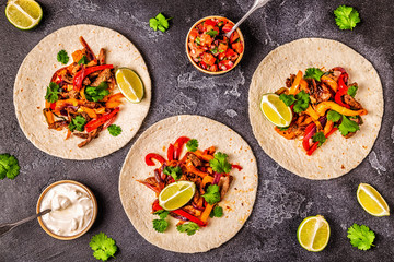 FAJITAS with colored pepper and onions, served with tortillas.