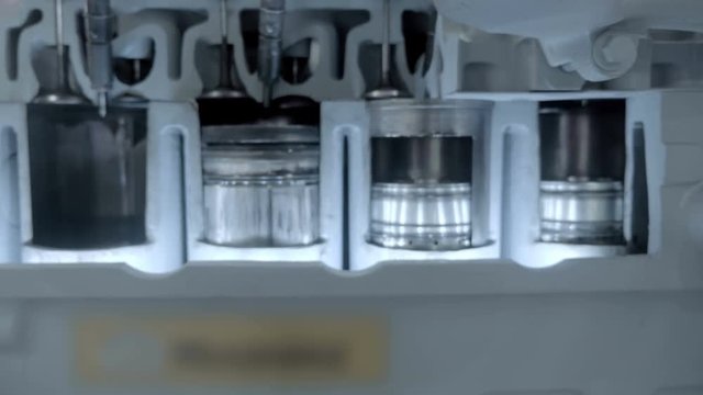 The movement of the cylinders of the internal combustion engine are visible on the sample with a cutting in the cylinder block. Shot in motion