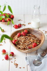 Healthy breakfast. Fresh granola, muesli with milk and berries on white background.