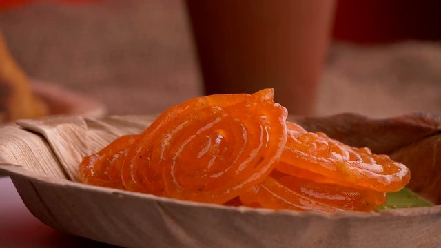 Delicious jalebis are served in a plate that is rotating. Jalebi is a very famous Indian dessert that is served during festivals, weddings and  parties.