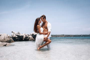 romantic  young couple in white clothes  enjoying summer vacation  on the beach. Passion. Phuket. Thailand.