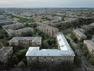Fototapeta na wymiar Aerial drone shot of downtown with house with new silver roof in the front. Summer day in Magnitogorsk, Russia