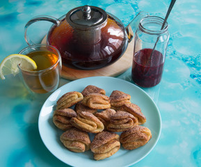 Biscuits with cottage cheese, tea with lemon and raspberry jam