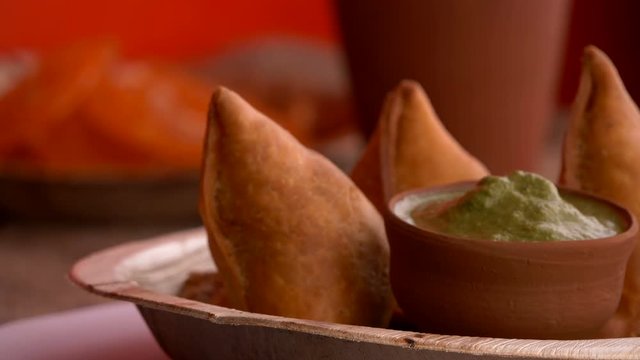 Delicious Samosas. They  are one of the most famous snacks in India. They are deep fried and are usually made with flour & potato stuffing.In this video the plate with the samosas are rotating.