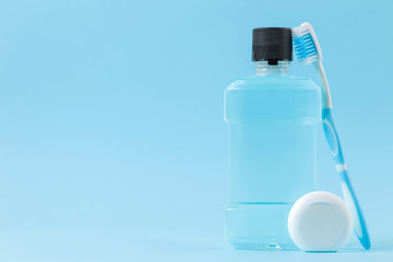 Oral hygiene. Toothbrush, dental floss and mouthwash for teeth and mouth on a gentle blue background. space for text