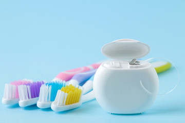 Oral hygiene. Multi-colored toothbrush and dental floss on a gentle blue background. space for text