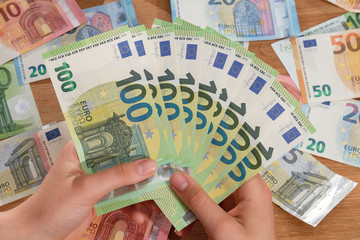 Hände fächern 100 EUR Banknoten
