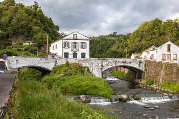 Fototapeta na wymiar Bridge over river and water mill building in Povoacao, Sao Miguel, Azores
