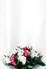 Close-up of a beautiful and stylish wedding bouquet of white and pink rose flowers on a white background. Top view, copy space