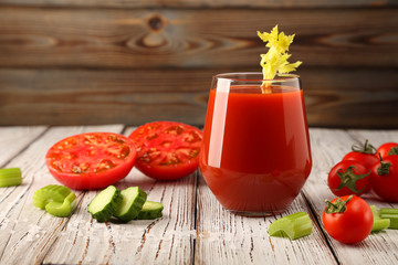 Tomato juice from fresh tomatoes and celery stalks with juicy tomatoes, and slices of sliced cucumbers.