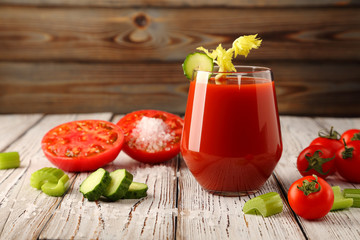 Tomato juice from fresh tomatoes and celery stalks with juicy tomatoes, and slices of sliced cucumbers.