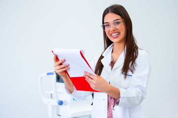 smiling ophthalmologist standing with diagnosis in clinic.