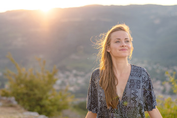 Young woman portrait. Young woman with sexy dress at sunset. Rhone valley in the background.