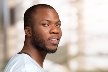 Portrait of stong and handsome african male student looking at camera smiling