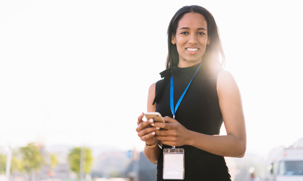 Professional young businesswoman with phone in sunlight