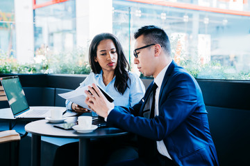 Professional young man and woman meeting in cafe