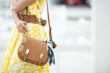 Women accessories closeup picture. Purse, sunglasses and the .kerchief. Brown handbag with fashion...