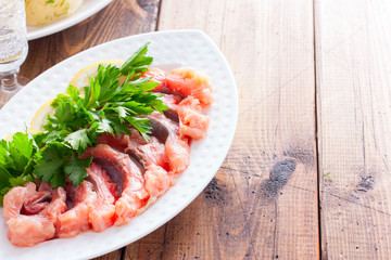 Home-salted pink salmon, cut into pieces on a white plate, horizontal, copy space