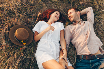a couple of lovers lying on the grass below, a picnic at sunset. Lifestyle and travel concept....