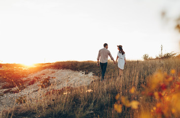 Man and woman looking at each other and walking together outdoors. a couple of lovers lying on the...