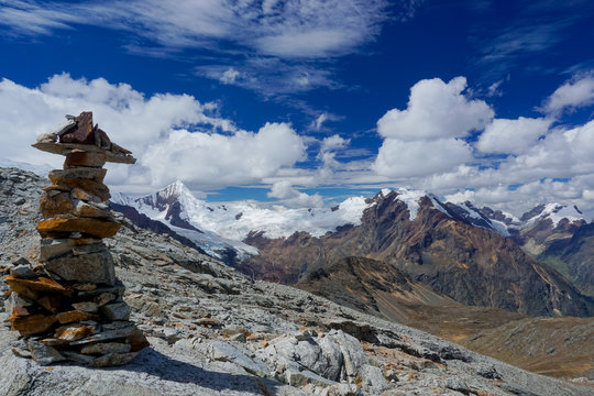 picturesque mountain landscape in the Andes of Peru with a stone cairn in the foreground