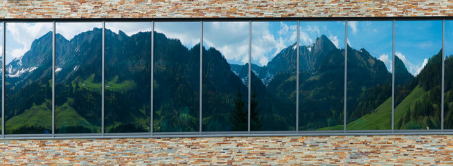 idyllic panorama mountain landscape view reflected in building windows