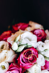 Close-up image of a beautiful and stylish wedding bouquet of white and pink flowers rose and rings. Top view, copy space