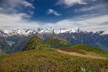 Fototapeta premium Panoramic view of the snow-capped peaks of the Alps in the upper Blenio valley in Switzerland, in spring.