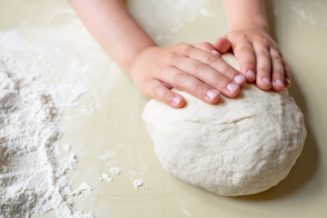 Closeup portrait of kids and adult hands making dough for pastry 