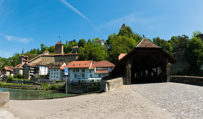 Fototapeta na wymiar view of the historic Place de Jean-Francois-Reyff Square and Bernbruecke covered bridge in the old town of the Swiss city of Fribourg